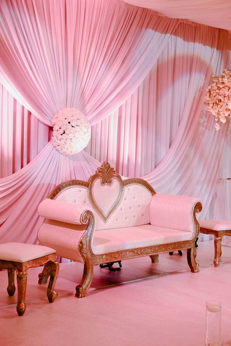 Ornate gold and red floral wedding stage backdrop with statement seating and drapery